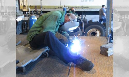 Technician welding custom flatbed.