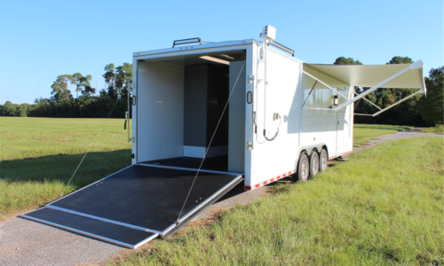 USCG trailer exterior, rear view showing rear door open and the retractable awning deployed.