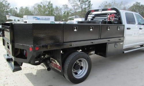 Curbside view of 11-foot flatbed with toolboxes.